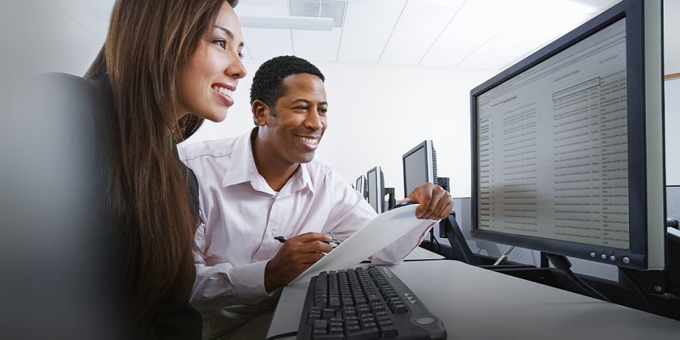 Two employees classifying emails on a computer screen.